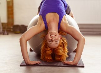 Frau trainiert ihren Rücken auf Gymnastikball