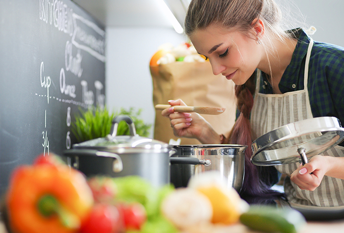 Frau kocht Suppe in der Küche